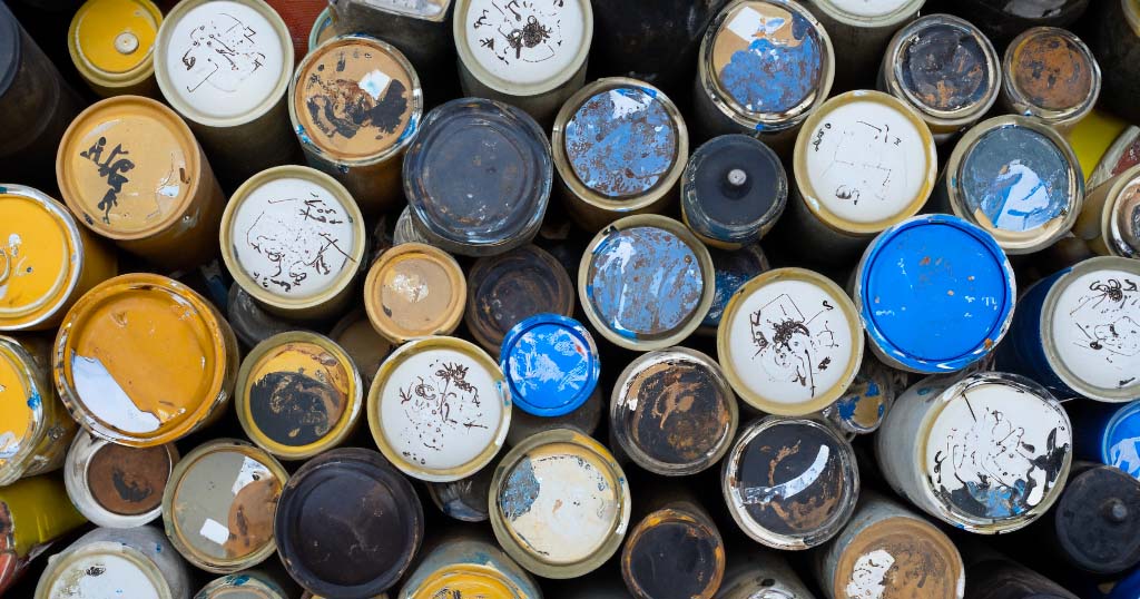 A close up of many different colored household oil cans.